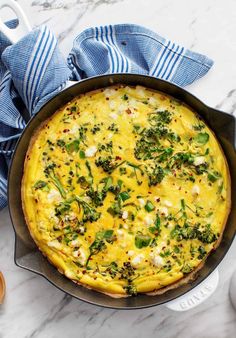 an omelet with broccoli and cheese in a pan