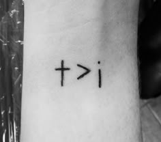 a cross tattoo on the wrist that reads i - kt and it is written in black ink