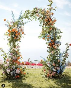 an arch made out of flowers in the grass