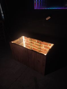 a brick fire pit in the middle of a dark room