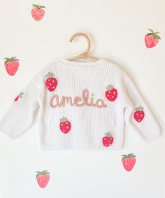 Create a custom white baby cardigan for your little one. Choose your color of yarn! These do run oversized- please size down. Our 12-18 has lasted us to 3t. You have the option of a floral letter on the back or a name with strawberries! Please choose 3 different yarn colors for the flowers- I will be using Olive and Artichoke already as the leaf colors. Please send me a message or find us on Instagram Belly__Co with any questions! Customizable Cute Winter Sweater, Cute Handmade White Sweater, Cute Customizable Winter Sweater, Cute White Handmade Sweater, Personalized White Sweater For Winter, Cute White Cotton Cardigan, Personalized White Cotton Sweater, Pink Cotton Sweater With Letter Embroidery, Cardigan Embroidery