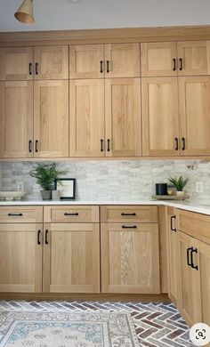 a kitchen filled with wooden cabinets and white counter tops next to a potted plant