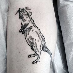 a small rat tattoo on the left thigh and right leg, it is black and white