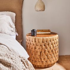 a bedroom with a wicker side table next to a bed