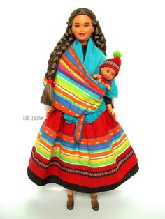 a doll is holding a baby in a colorful dress