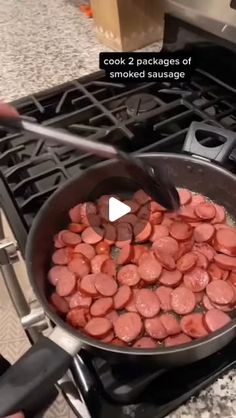 someone is cooking hot dogs in a pan on the stove