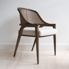 a wooden chair sitting on top of a hard wood floor next to a white wall