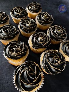 twelve cupcakes with chocolate frosting in the shape of a rose