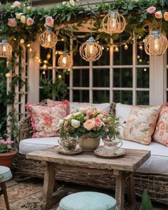 an outdoor seating area with flowers and lights