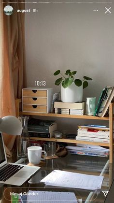 a glass desk with a laptop and books on it, along with other office supplies