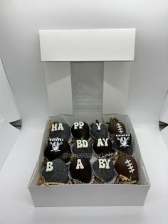 a box filled with chocolate covered strawberries in the shape of footballs and letters