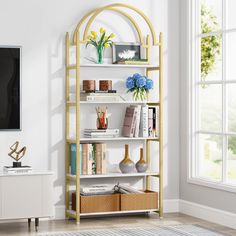 a living room with a blue couch and a gold shelving unit filled with books