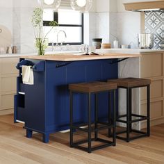 an island in the middle of a kitchen with stools