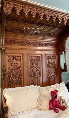 a teddy bear sitting on top of a bed with wooden headboard and foot board