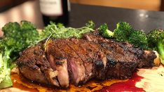 a piece of meat and broccoli on a cutting board