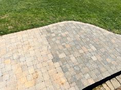 a brick walkway with grass in the background