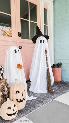 two halloween decorations are sitting on the front porch