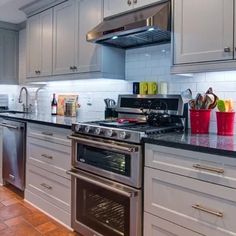 a kitchen with stainless steel appliances and white cabinets