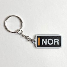 a keychain with the word nor written in orange and black on it's side