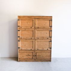 a large wooden cabinet sitting next to a white wall