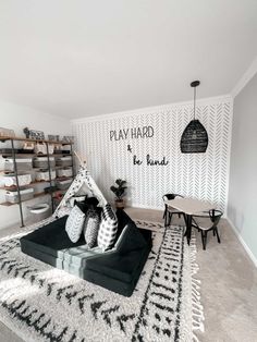 a living room with an area rug and black and white decor on the wall,