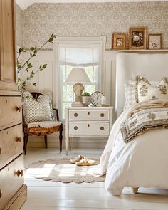 a bed room with a neatly made bed and a night stand next to a window