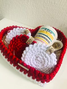 a crocheted heart shaped basket with toothbrushes and lotion