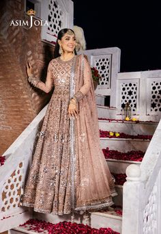 By Pcs: 3 Pcs Peshwas: Chiffon Trouser: Twisted Silk Dupatta: Chiffon Color: Pink Product Details Behold the epitome of elegance with this pale tea-pink peshwas from Asim Jofa's "Jaan-e-Jahan Chiffon Collection" where artistry meets sophistication in a symphony of bronze copper zariwork and self-color threadwork along with silver plain 9mm and cupped 3mm sequins. The intricate florets of 9mm silver sequins encompassed with cupped 3mm sequins densely arranged on the ensemble creating a mesmerizin Semi-stitched Sequin Dress For Reception, Eid Reception Dress With Dabka Detailing, Party Wear Dresses With Dupatta For Reception, Party Wear Dresses With Sheer Dupatta For Festive Occasions, Festival Dresses With Dupatta For Reception, Festival Reception Dress With Dupatta, Sequin Anarkali Dress For Reception, Anarkali Dress With Dupatta For Reception, Party Wear Maxi Dress With Sheer Dupatta