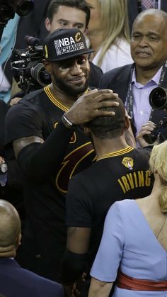 two men are hugging each other in front of the crowd at a sporting event with cameras around them