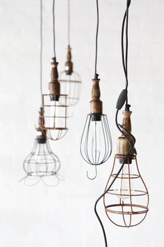 several light bulbs hanging from wires with wire and wood on the top, one is turned upside down