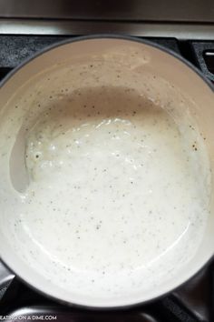 a white sauce in a pan on top of a stove