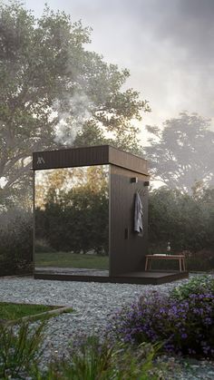 an outdoor shower in the middle of a gravel area with trees and bushes around it