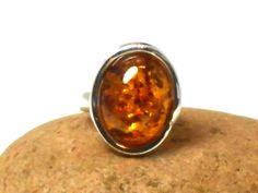 A smart large cognac Amber ring set in a stylish Sterling Silver design and gift boxed.  Size of Amber: 14 x 19 mm. Weight - 8.6 g. Amber is technically not a gemstone or mineral, but a fossilised sap from prehistoric trees that has aged over the course of millions of years. Amber is usually thought of as yellow golden in hue, but amber also can be found in shades of milky white, red-orange, green, black and even (very rarely) violet. Early physicians prescribed amber for headaches, heart proble Formal Amber Oval Cabochon Rings, Classic Amber Rings For Gifts, Formal Brown Cabochon Rings, Formal Brown Rings With Polished Finish, Modern Brown Rings For Gifts, Modern Brown Rings For Gift, Brown Polished Finish Ring As Gift, Brown Ring With Polished Finish For Gift, Brown Rings With Polished Finish For Gift