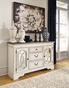 a white dresser with two vases on top of it