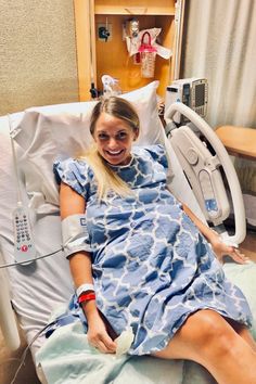 a woman laying in a hospital bed smiling