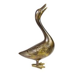 a bronze duck statue sitting on top of a white surface