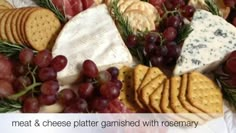 an assortment of cheeses, crackers and grapes on a platter with rosemary