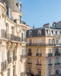 an apartment building with balconies and balcony railings in paris, france on a sunny day