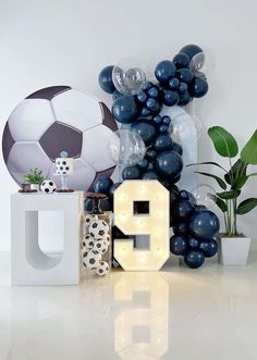 the letters g are made out of balloons and soccer balls in front of a white wall