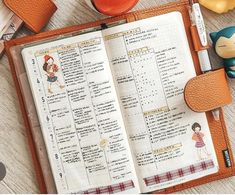 an open planner with some little figurines on it and a cup of coffee