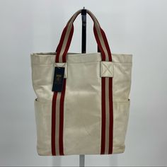 Bally Stripe Leather Tote Bag Cream And Red Bag 13x5x15. 5” Drop. Aabl Includes Original Care Card Item Has Three Interior Pockets, Two Exterior Pockets At Sides Of Bag. Item Shows Signs Of Wear From Normal Use: Creasing, Discoloration, Scratches, And Staining On The Exterior Throughout, More Heavily At Base. Interior Shows Milder Wear, But Has Staining/Discoloration In Particular Areas. Please Refer To Photos For Further Details. Sku: Jp082008 Sporty Red Rectangular Bag, Bally Bag, Red Tote Shoulder Bag With Silver-tone Hardware, Red Tote Bag With Gold-tone Hardware, Red Bag, Care Card, Leather Tote Bag, Leather Tote, Red White