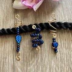 This listing is for a set of 3  gold coil loc, dreadlock, braid, or twists charms. Each features royal blue/sapphire Czech glass beads. One is covered in AB beads, one has a reversible heart charm, one has a reversible leaf charm. (one side is AB blue and is gold on the other side-see pic 2).  ["AB" is Aurora Borealis, a coating which creates different shimmering colors in the light.] Size: As shown, opening in coils is 8mm.  Made with 20g tarnish resistant gold wire.  If you need a different size opening (other than 8mm as shown), please add a note to seller at checkout with the size needed. (Smallest size available for this style is 4mm). All items are lead and nickel free. Braid Charms, Loc Accessories, Dreadlocks Hairstyles, Dreadlock Jewelry, Braid Accessories, Bead Hair Accessories, Beads Candy, Beaded Hair, Loc Jewelry