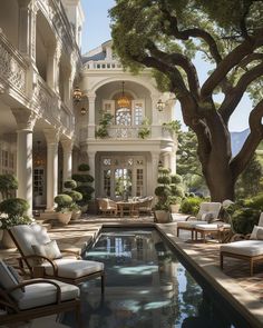 an outdoor swimming pool with chairs and trees in front of the house, surrounded by greenery