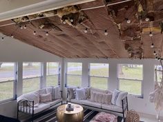 a living room filled with furniture and windows covered in tinsela foil hanging from the ceiling