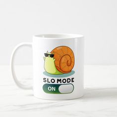 a white coffee mug with a cartoon snail on it's side and the words slo mode on