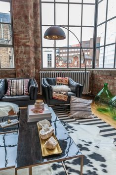 a living room with two couches and a coffee table in front of large windows