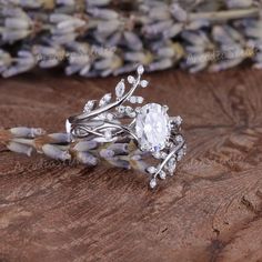 a close up of a ring on a piece of wood with flowers in the background