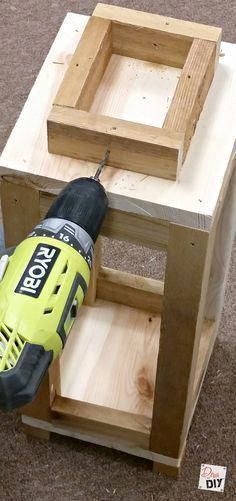 a drill is being used to attach the top of a wooden box with plywood