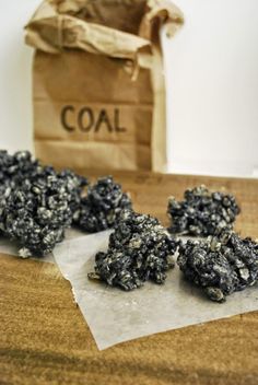 black and white cookies sitting on top of a wooden table next to a brown bag