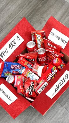 a red box filled with candy on top of a wooden floor